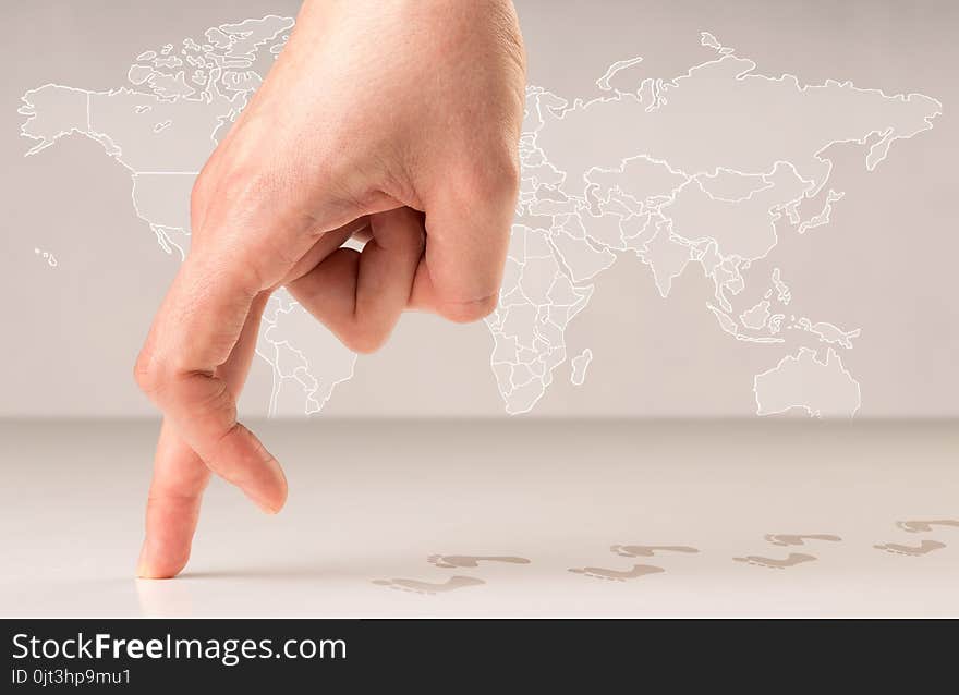 Female fingers walking with footsteps behind them and a world map in the background. Female fingers walking with footsteps behind them and a world map in the background