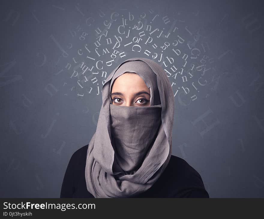 Young muslim woman wearing niqab with white alphabet letters above her head