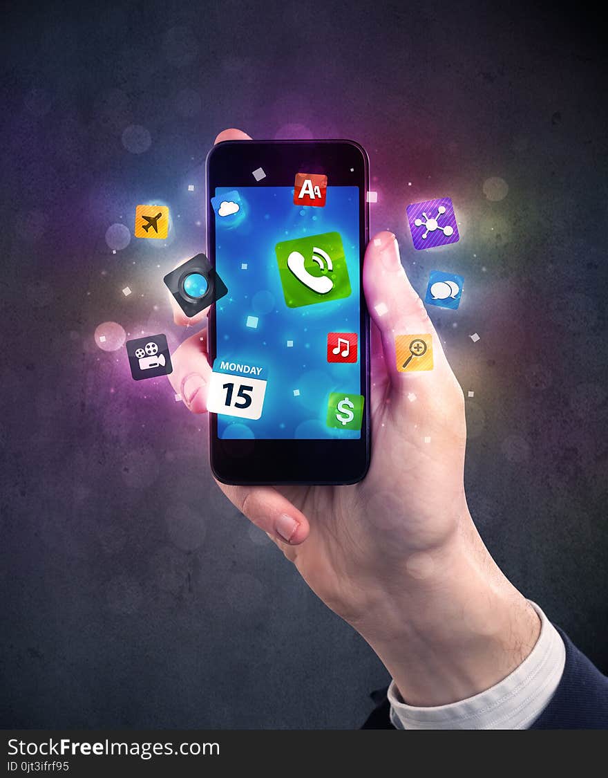 Caucasian hand in business suit holding a smartphone with colorful media icons. Caucasian hand in business suit holding a smartphone with colorful media icons