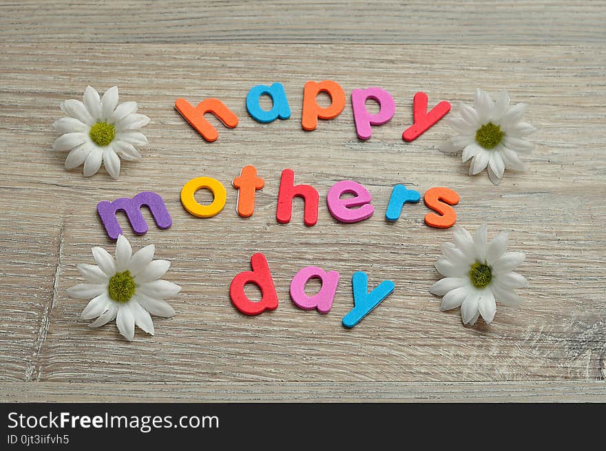 Happy mothers day in colorful letters with white daisies