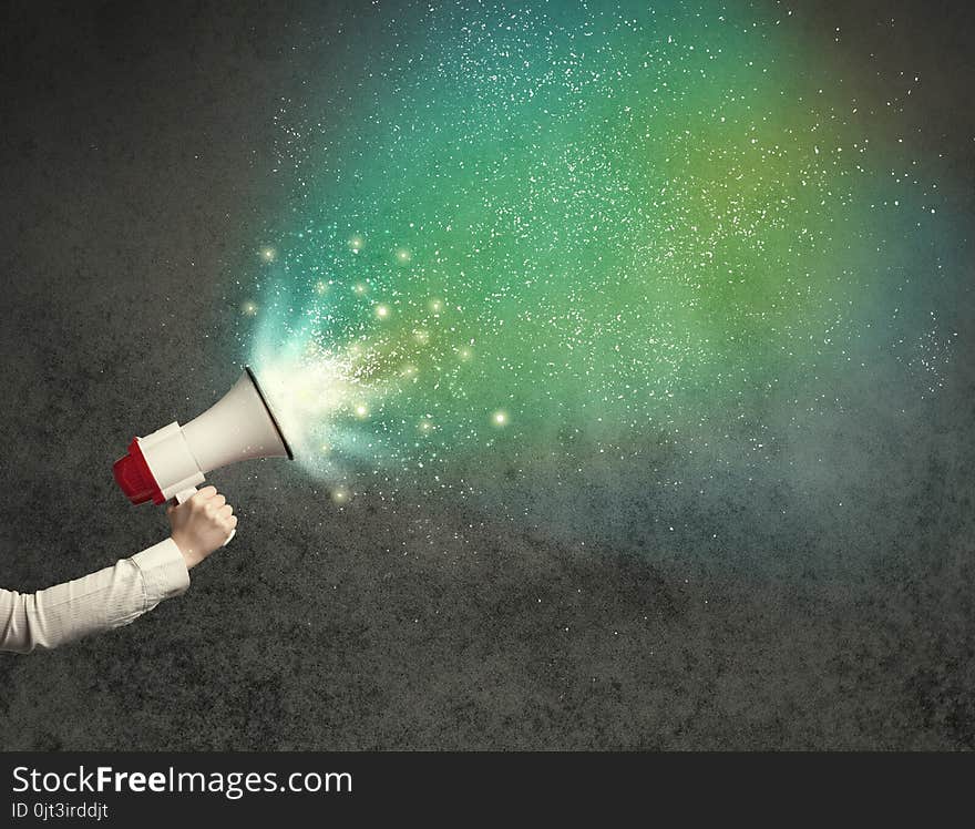 Caucasian business hand holding megaphone with white sparkles on a grunge background