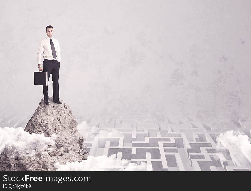 Businessman on cliff above labyrinth