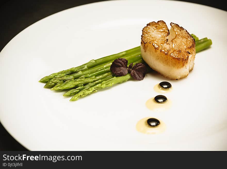 Scallop With Green Asparagus On White Plate