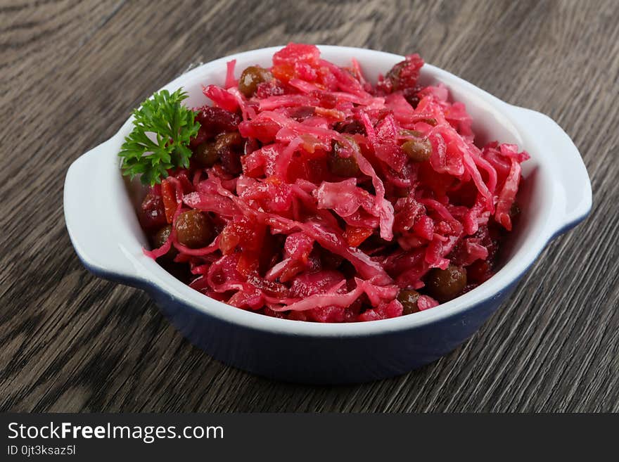 Viniagrette russian salad served parsley on wood background