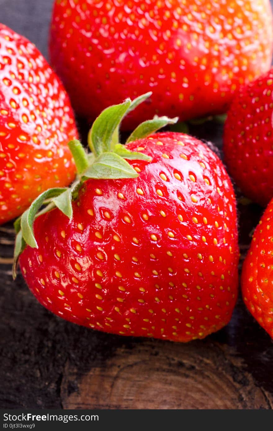 Sweet and fresh strawberry on dark background. Natural food. Vertical. Close-up.