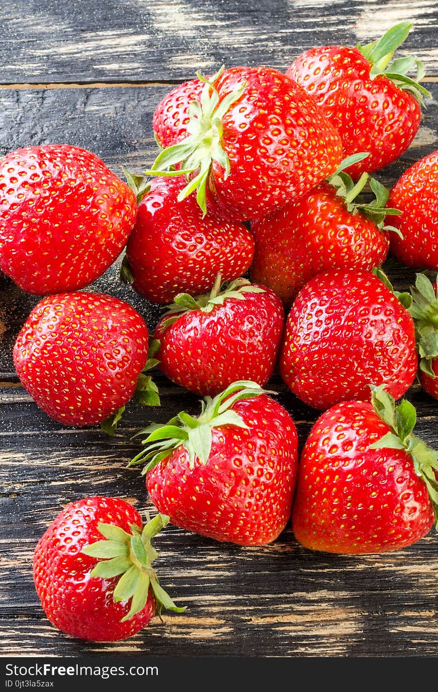 Sweet and fresh strawberry on dark background. Natural food. Vertical. Close-up.