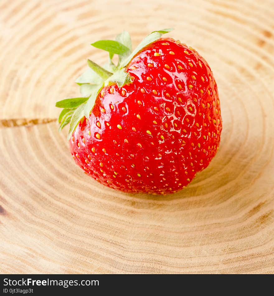 Sweet and fresh strawberry on light-brown stump background. Natural food. Square.