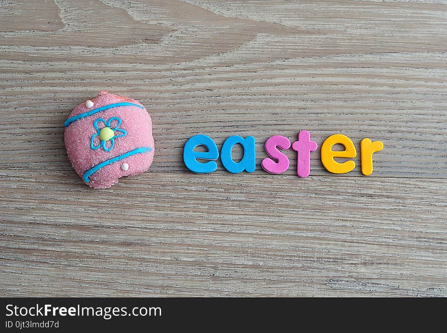 An egg shape marshmallow with the word easter on a wooden background