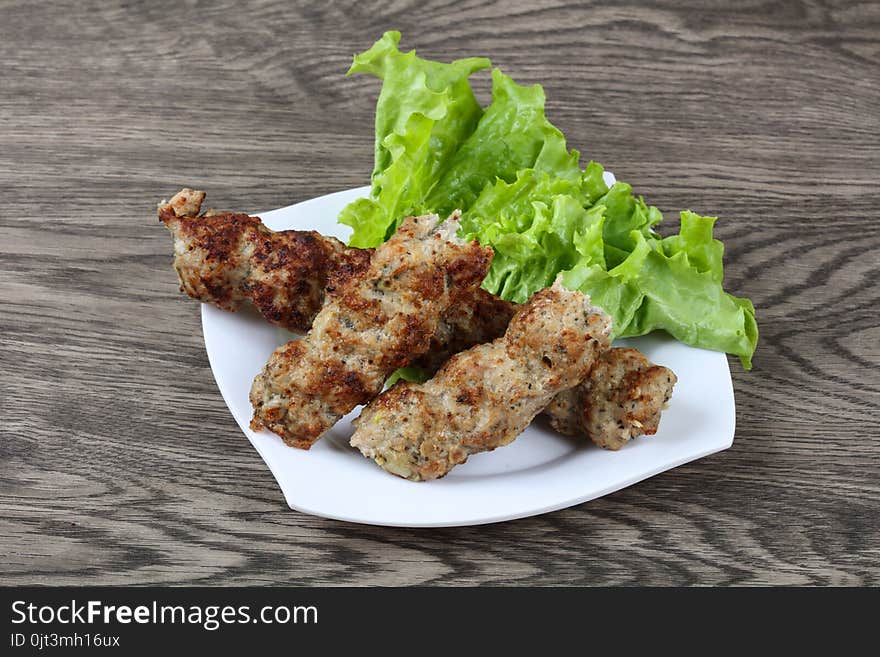 Meat kebab with green salad leaves