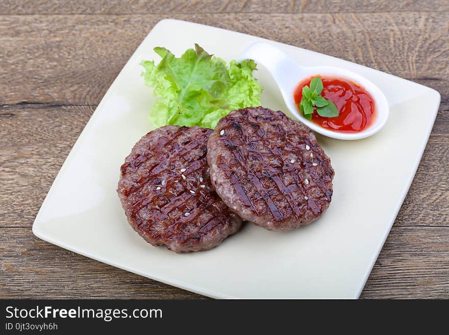 Grilled burger cutlet with onion and salad leaves