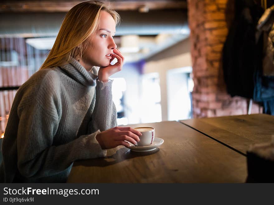 Young Beauty Woman In A Cafe Drinking Coffee