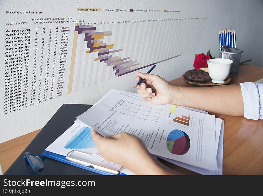 Hands of Business woman working on her desk. Reading chart and graph Business Concept.