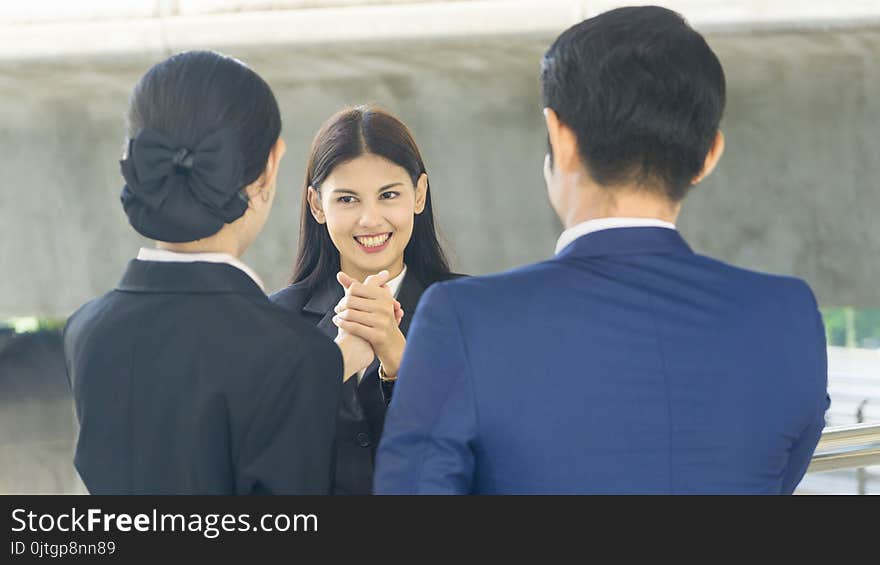 Group of business people of men and women stand and hold hands together in the feeling of happy and success at the outdoor pedestrian walk way. Group of business people of men and women stand and hold hands together in the feeling of happy and success at the outdoor pedestrian walk way