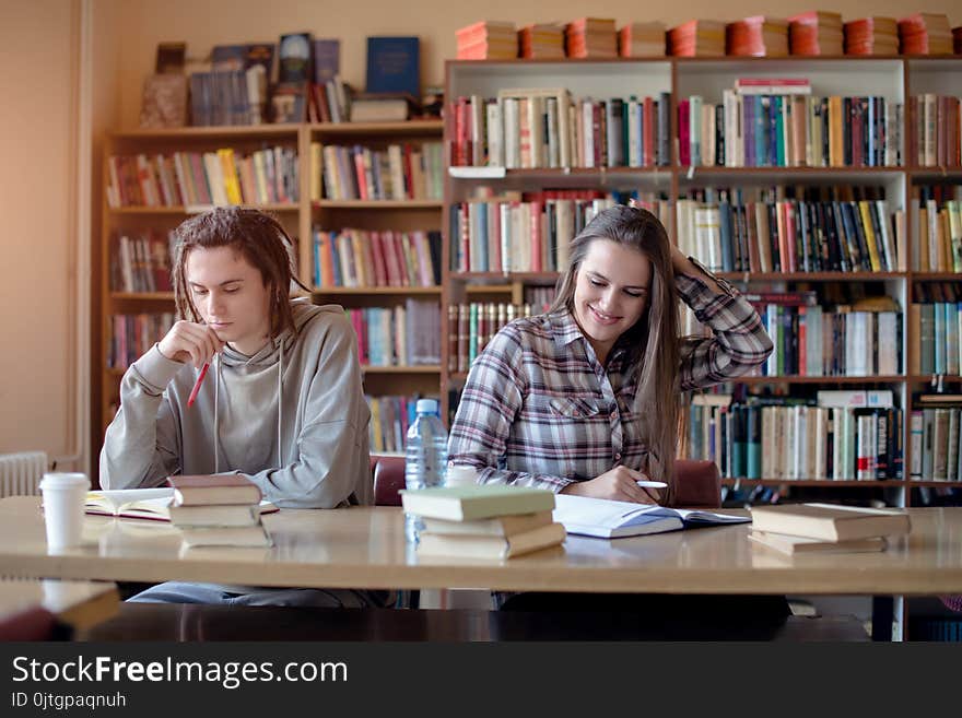 Happy students in library doing their homework.