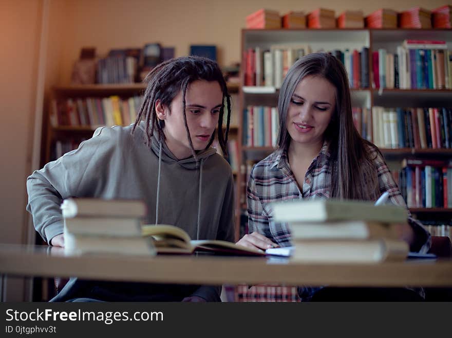 Two students learning together in library, front view.