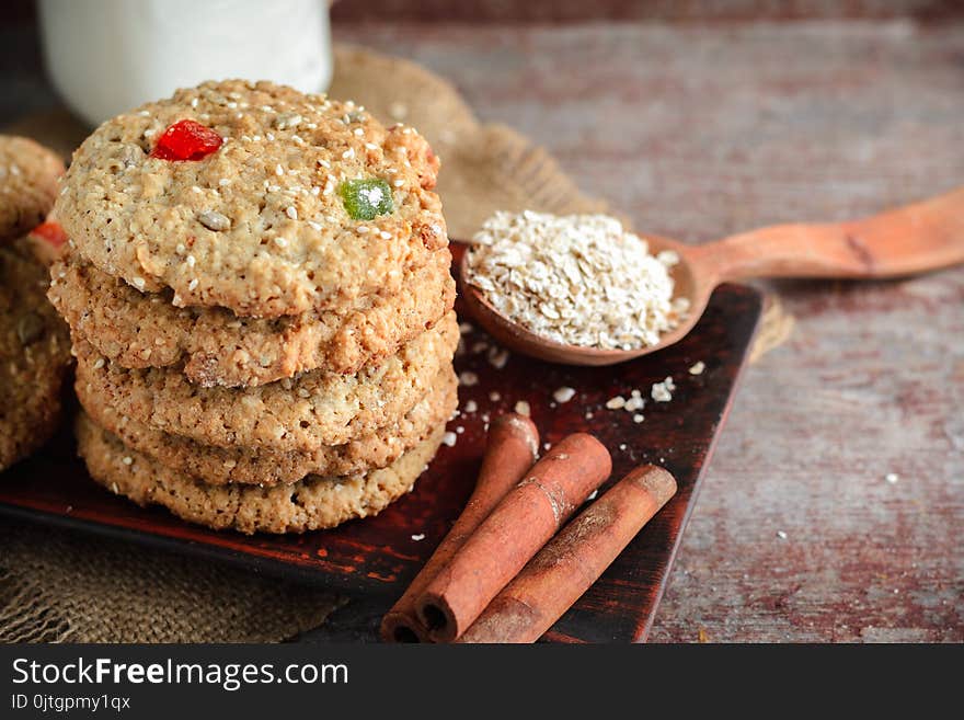 Oatmeal cookies, cinnamon sticks and milk on a wooden table. Oatmeal cookies, cinnamon sticks and milk on a wooden table