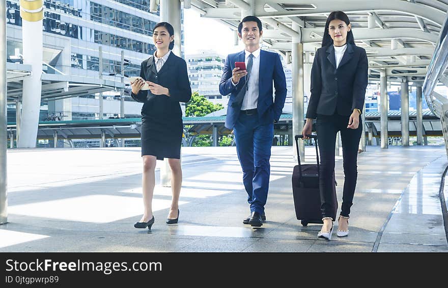 The business people walk outdoor pedestrian walkway