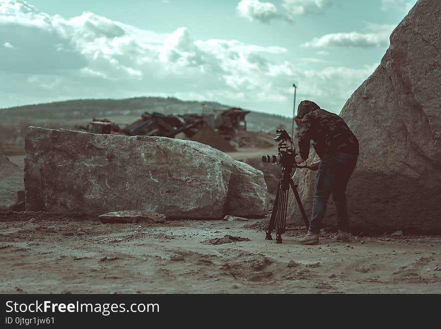 Video camera operator working with his video equipment in the stone quarry during day time.