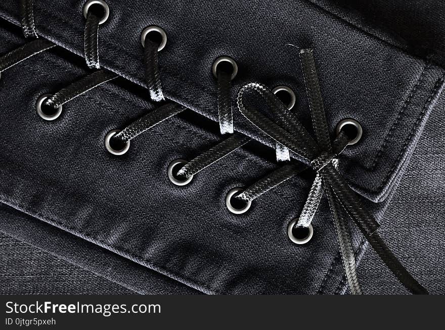 Washed black denim, lace-up details. Jeans background, texture