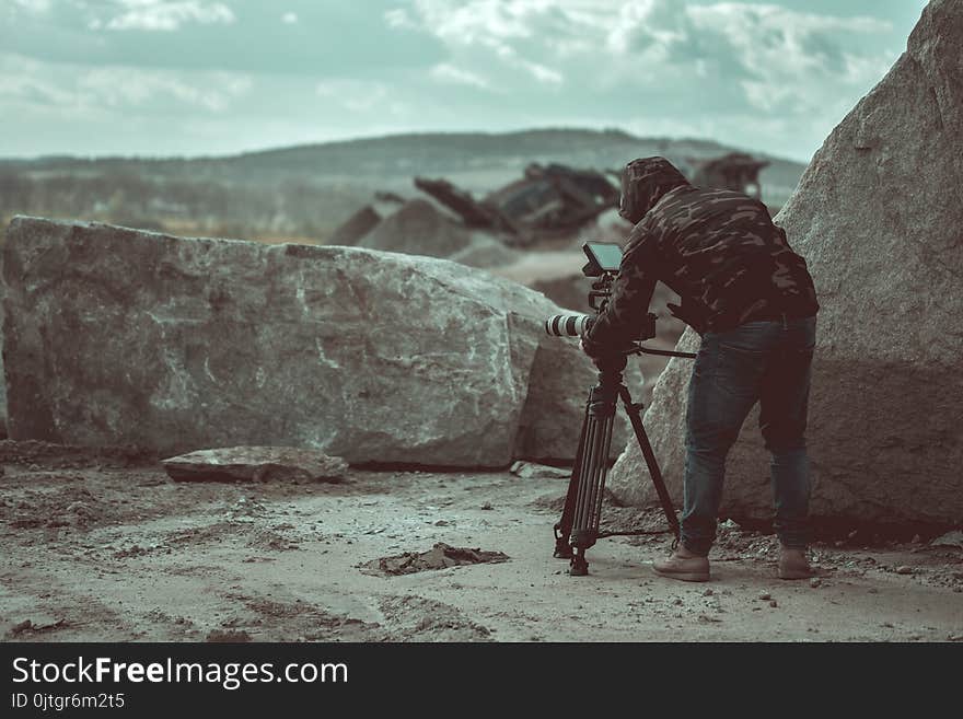 Video camera operator working with his video equipment in the stone quarry during day time.