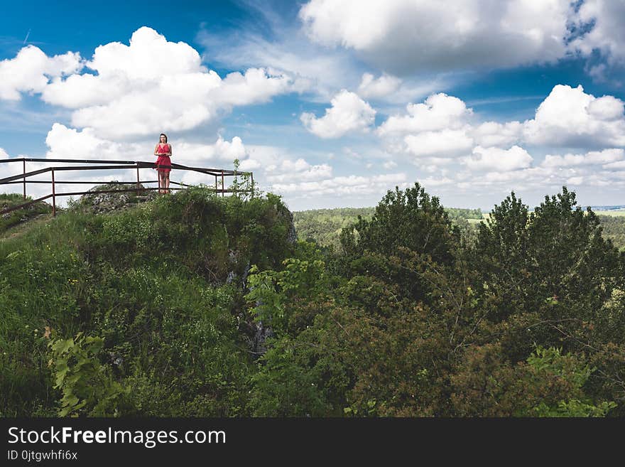 Girl in red dress at edge of the cliff