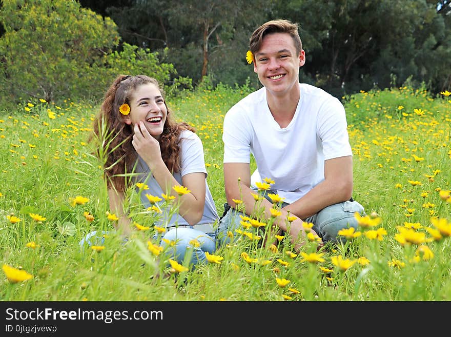 A teenage young couple walking in a field of chrysanthemum