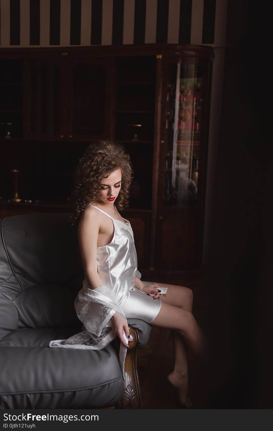 Curly haired girl sitting on the back of the couch