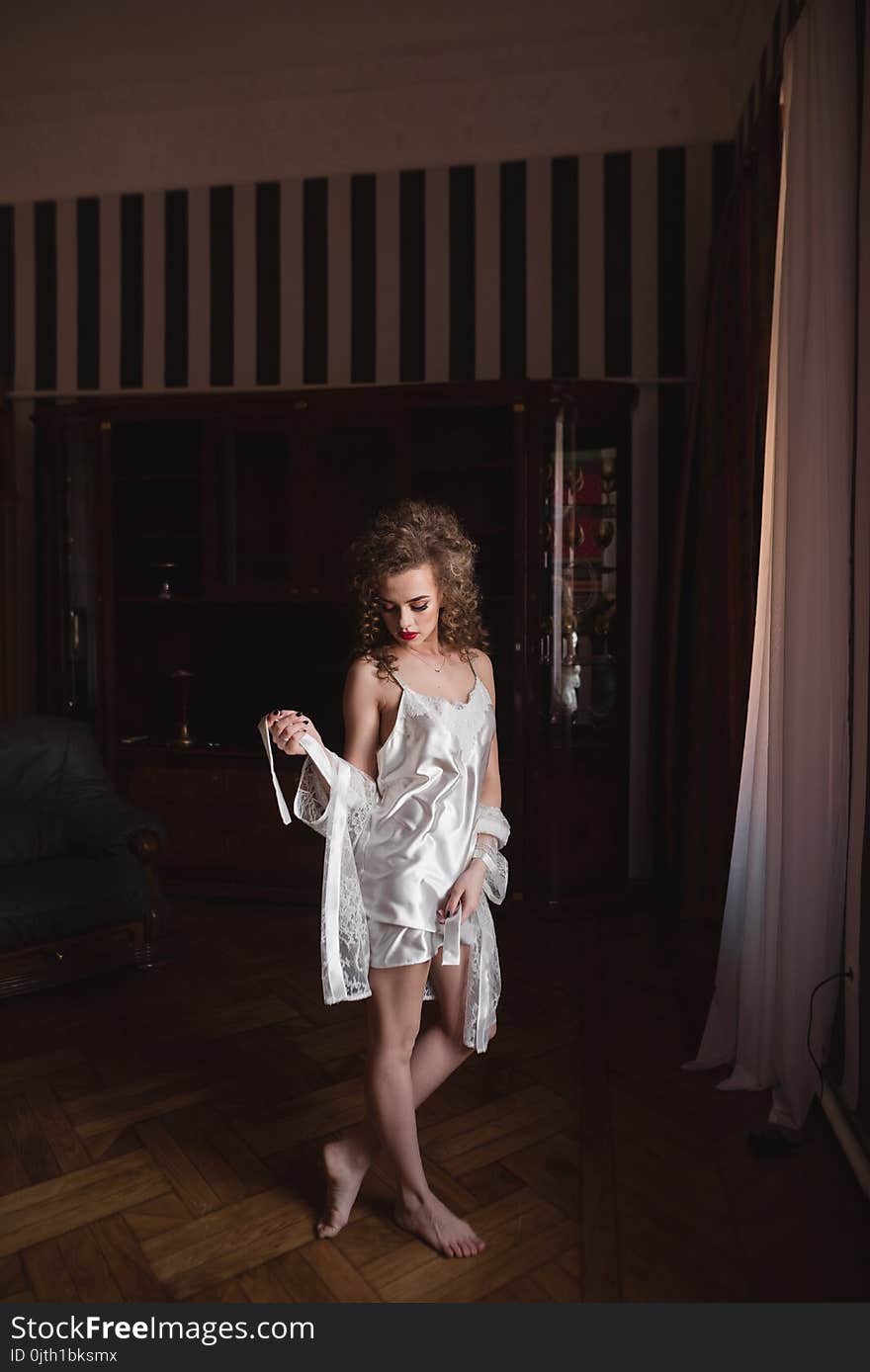 Beautiful Woman In White Silk Robe Standing Near Window