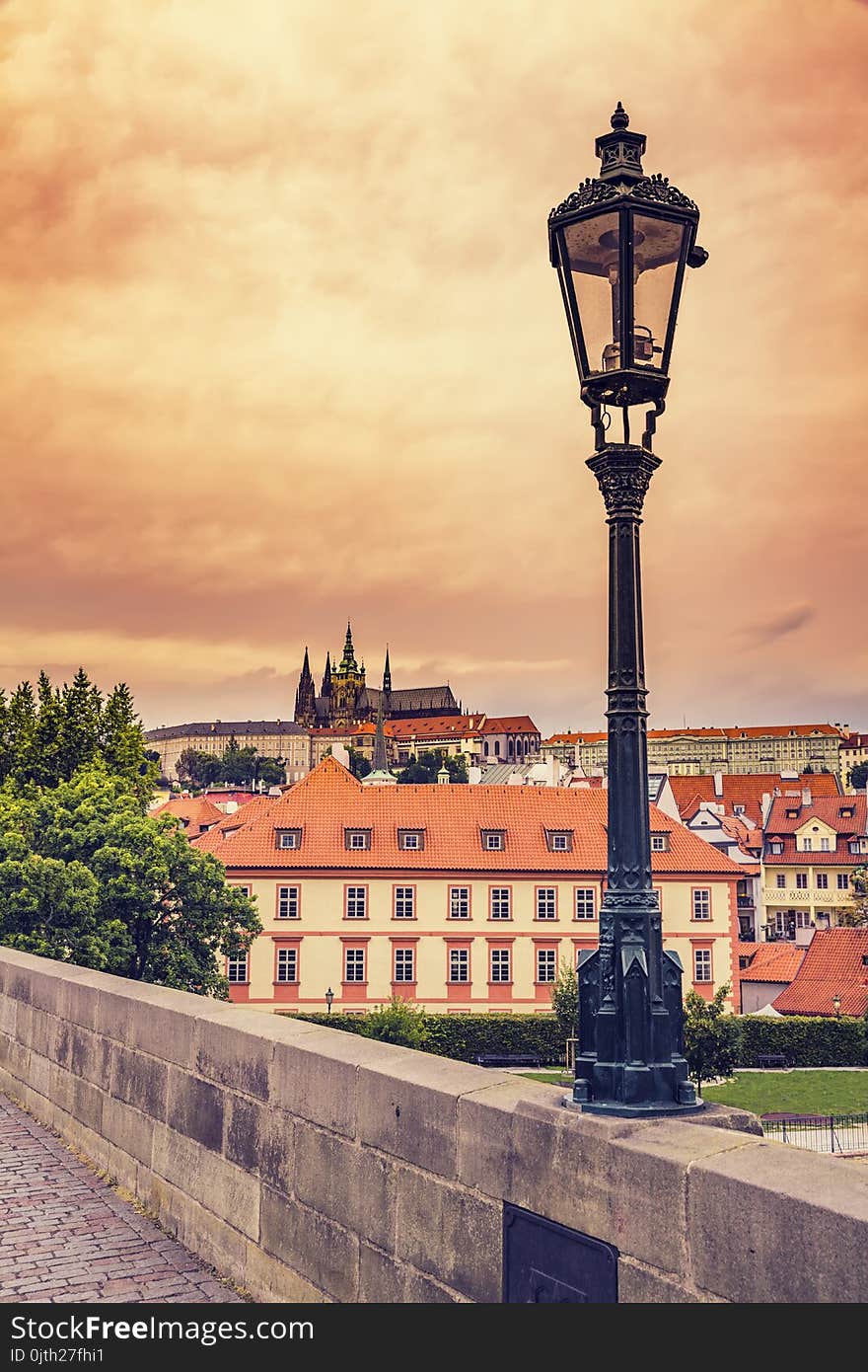 Beautiful evening sunset scenery Of the Old Town and Charles Bridge over Vltava river in Prague, Czech Republic / Old Street Lamp At Sunset On Charles Bridge in Prague