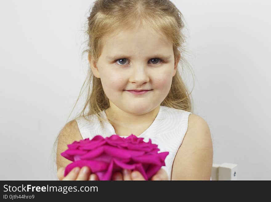 Portrait of a cute girl with a pink rose