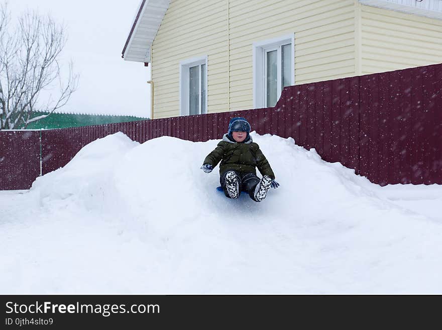 Warmly dressed boy riding on a snowy hill. Warmly dressed boy riding on a snowy hill