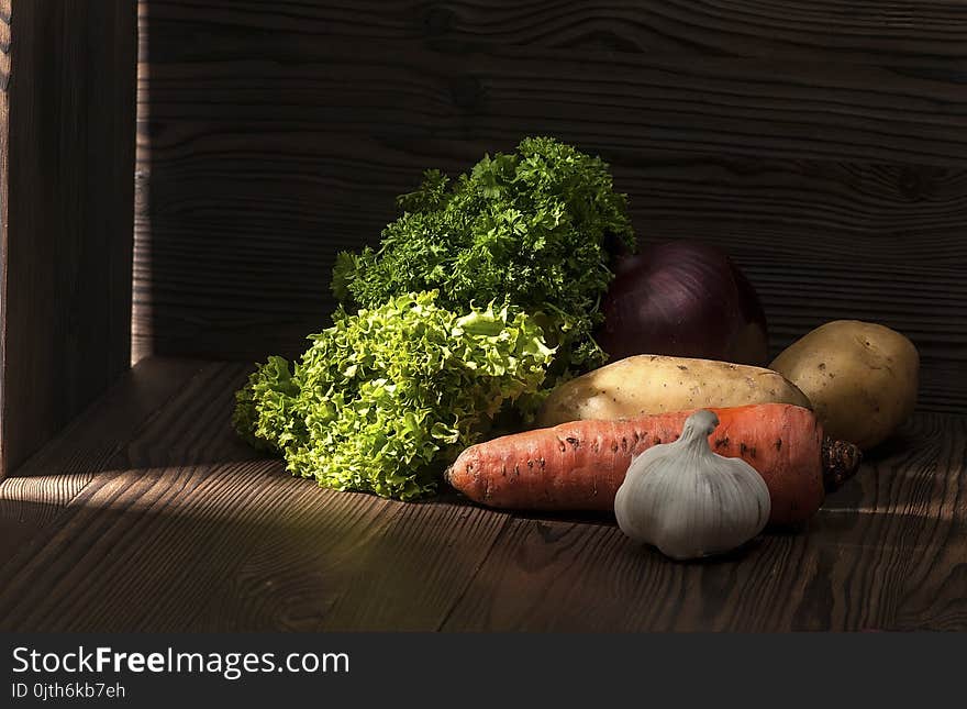 Greens and root crops on a dark rustic table