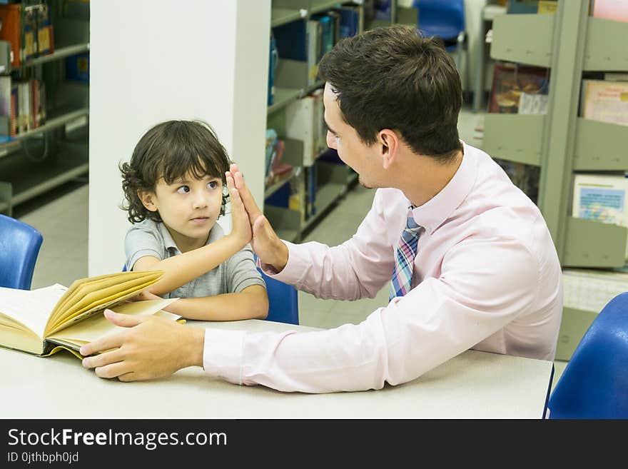 Man Teacher And Kid Student Learn With Book At Bookshelf Background