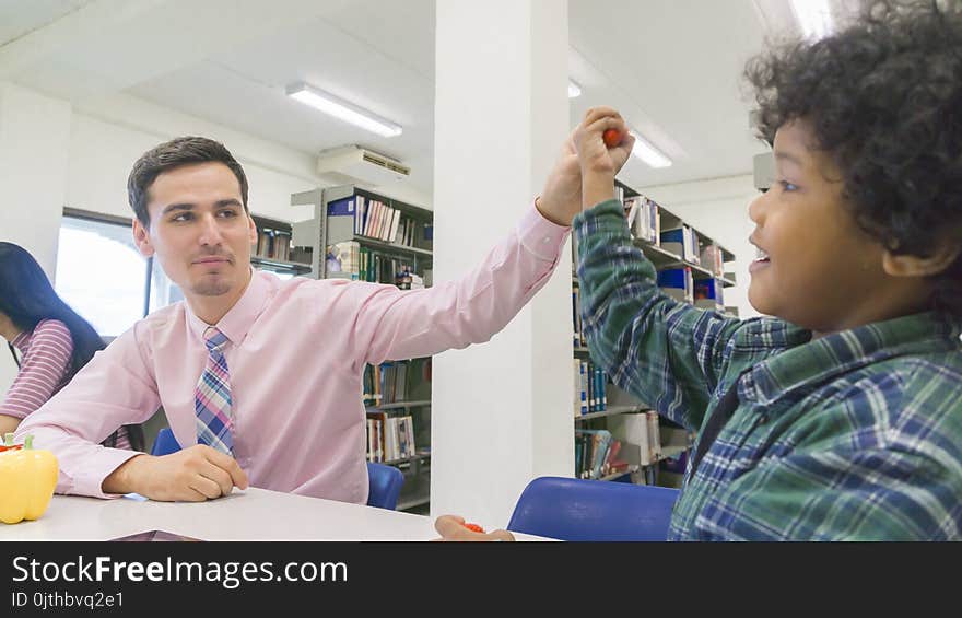 Man Teacher And Kid Student Learn With Book At Bookshelf Background