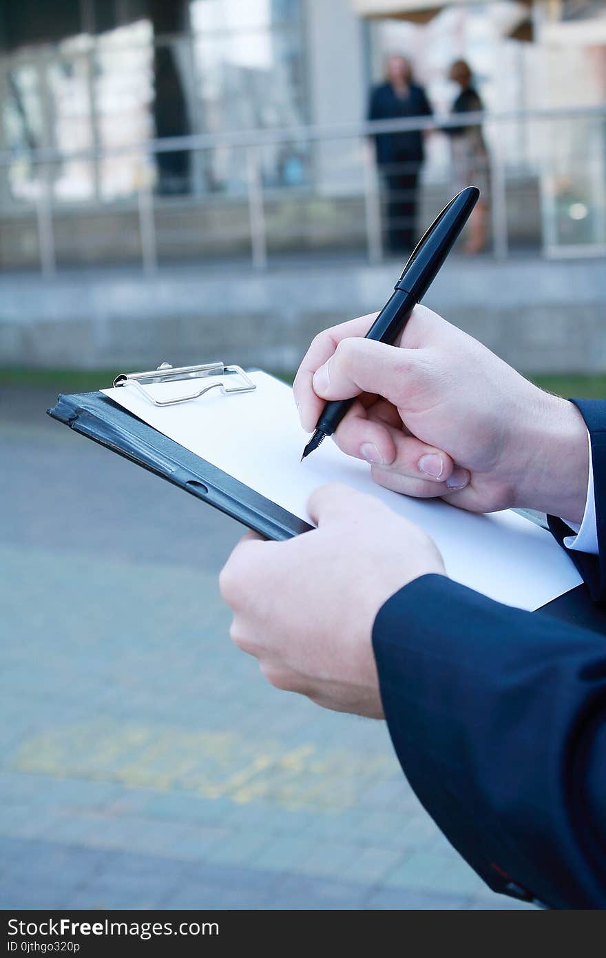 Close up. businessman making notes on the clipboard