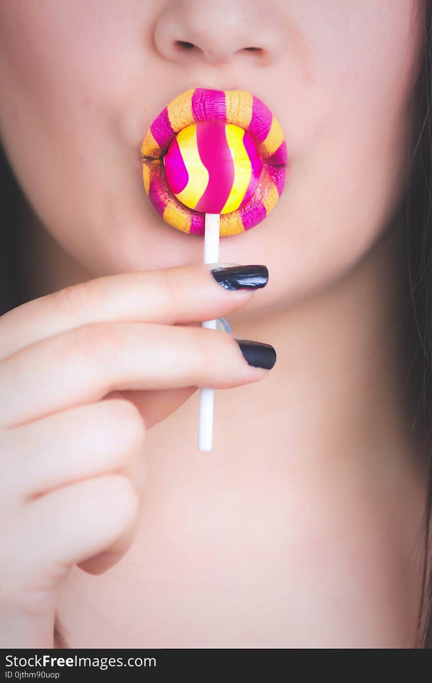 Woman Holding Yellow and Pink Candy