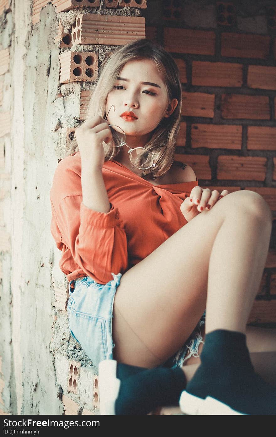 Woman Sitting on Concrete Ground