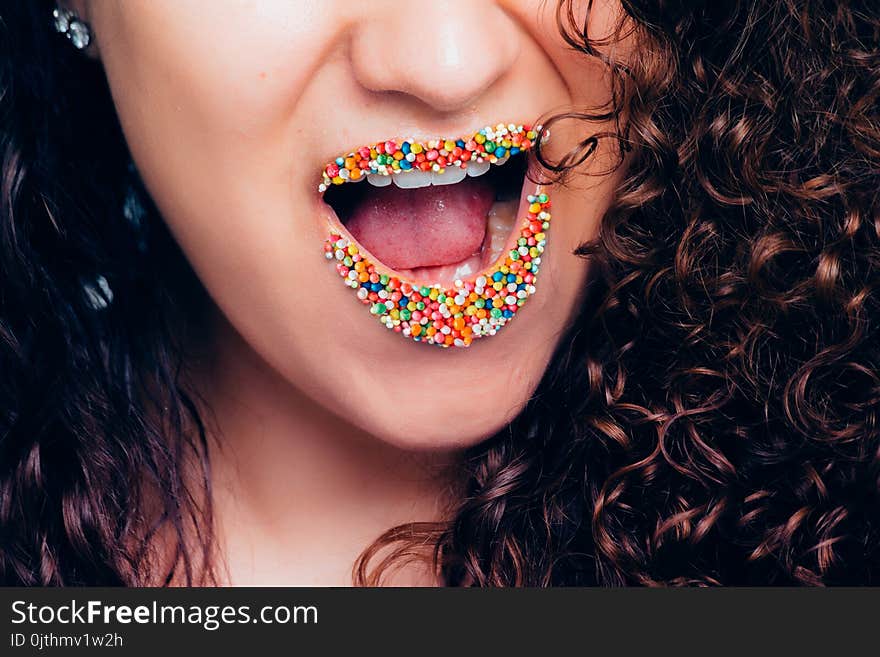 Woman Opening Her Mouth With Multicolored Sweets