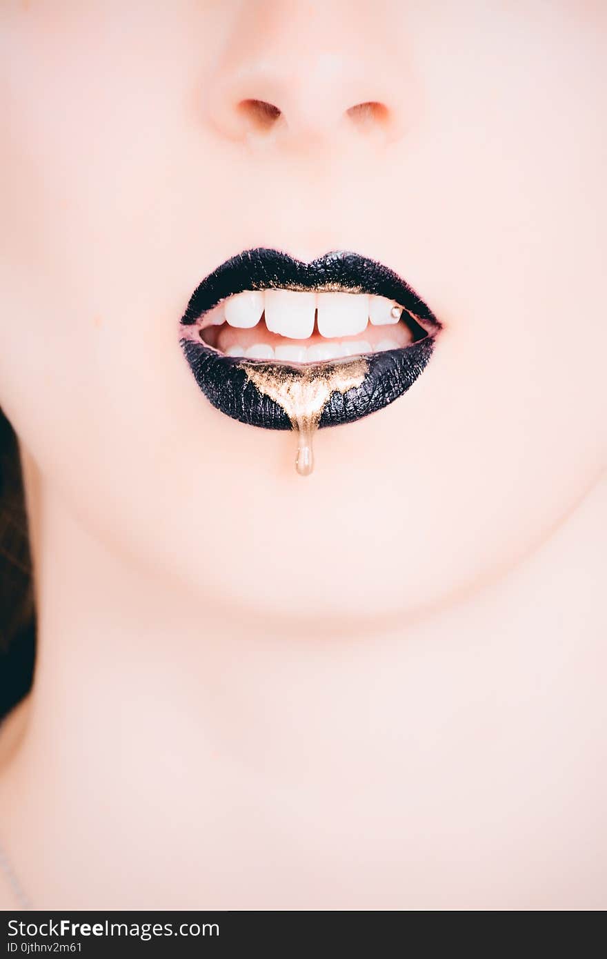 Woman Wearing Black Lipstick With Gold Dripping Out