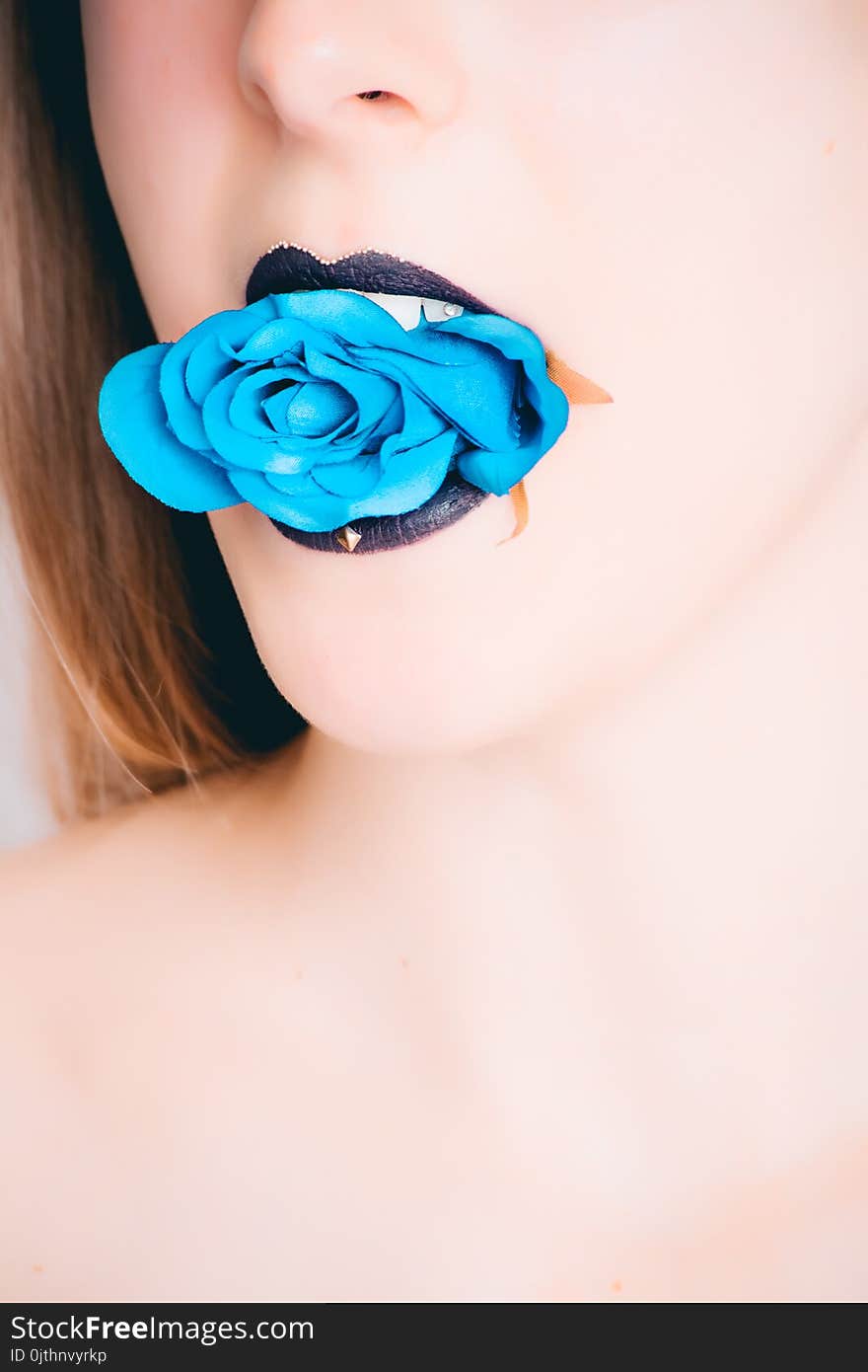 Woman With Black Lipstick Biting Blue Rose