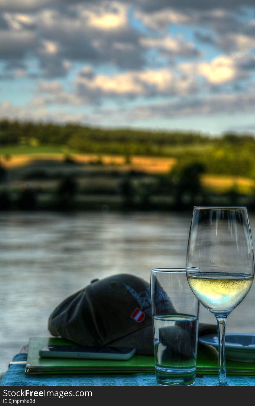 Clear Wine Glass Near Baseball Cap