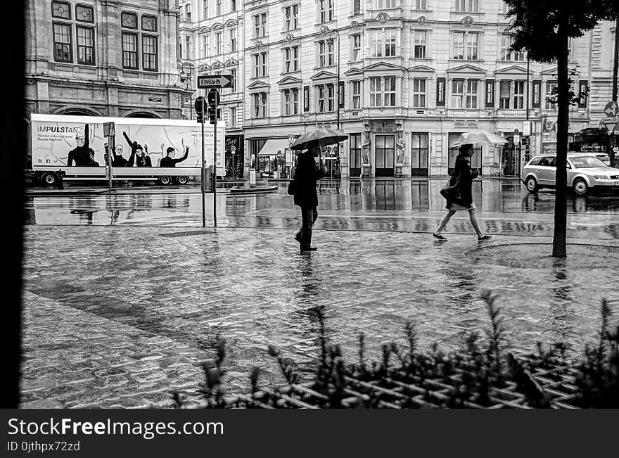 Man and Woman Walking on Road While Holding Umbrella