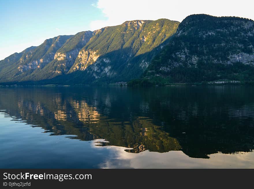 Photography of Body of Water Beside Green Mountain