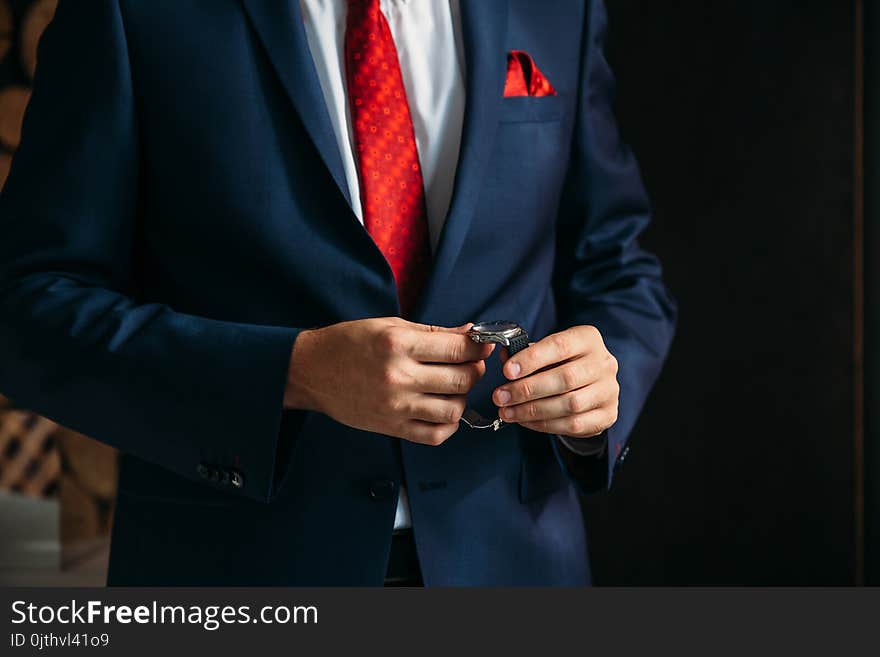 Businessman checking time on his wristwatch. men`s hand with a watch.