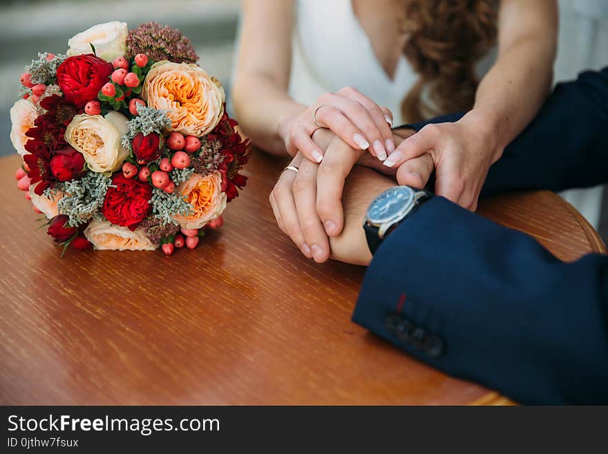 Closeup groom and bride are holding hands at wedding day and show rings. Concept of love family