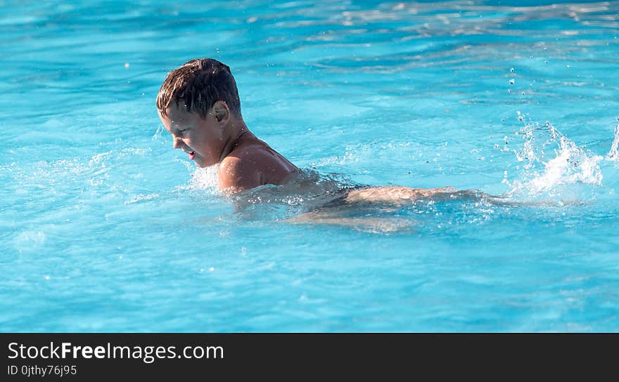 Boy swims with a splash in the water park