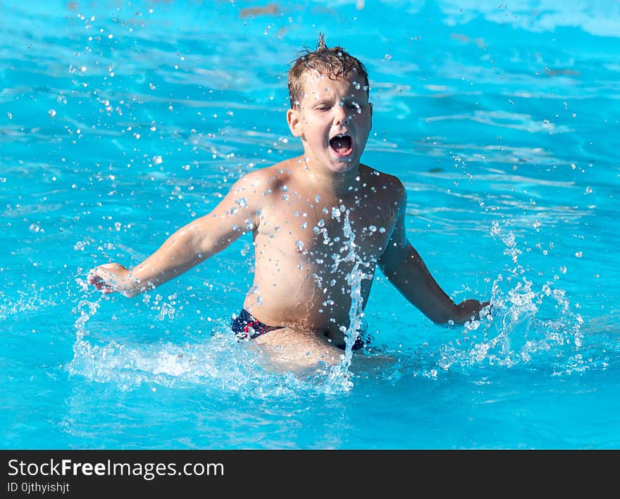 Boy swims with a splash in the water park .