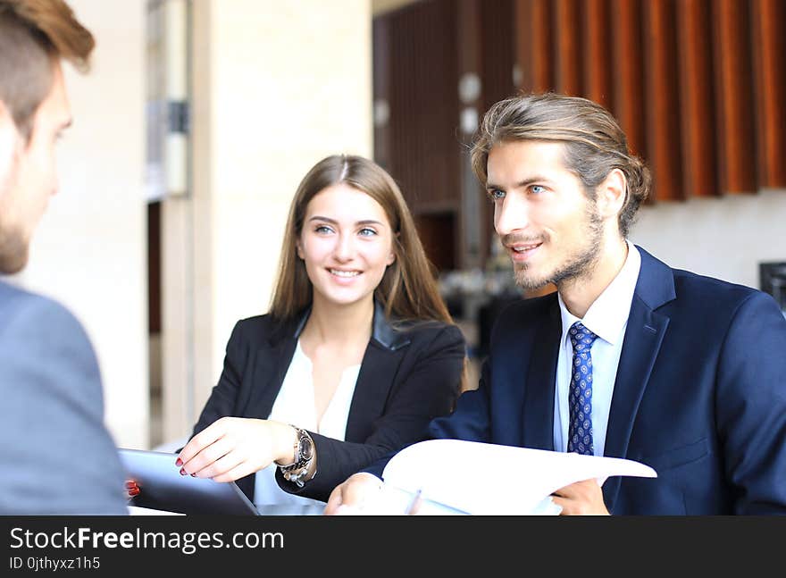 Businessman smiling happily as his business partner finally signing important contract.