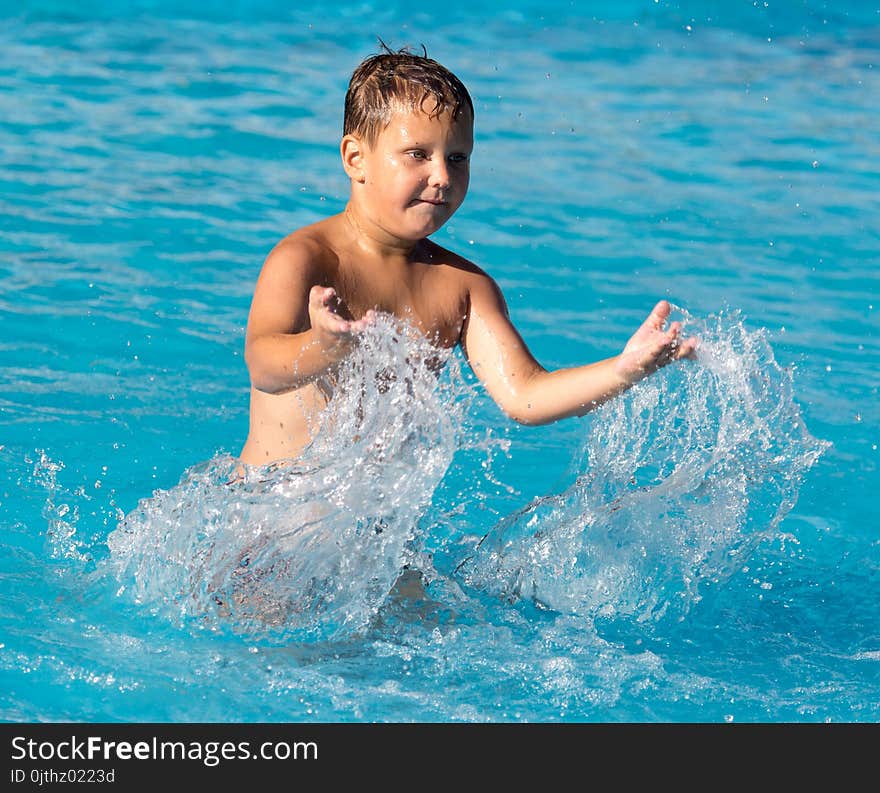 Boy swims with a splash in the water park .