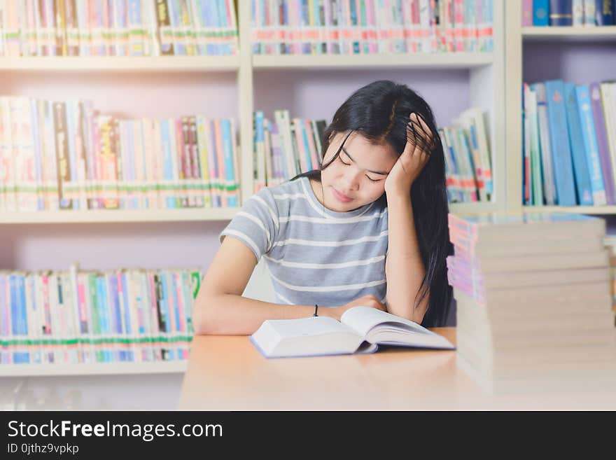 Portrait of clever Asian student exhausted for reading